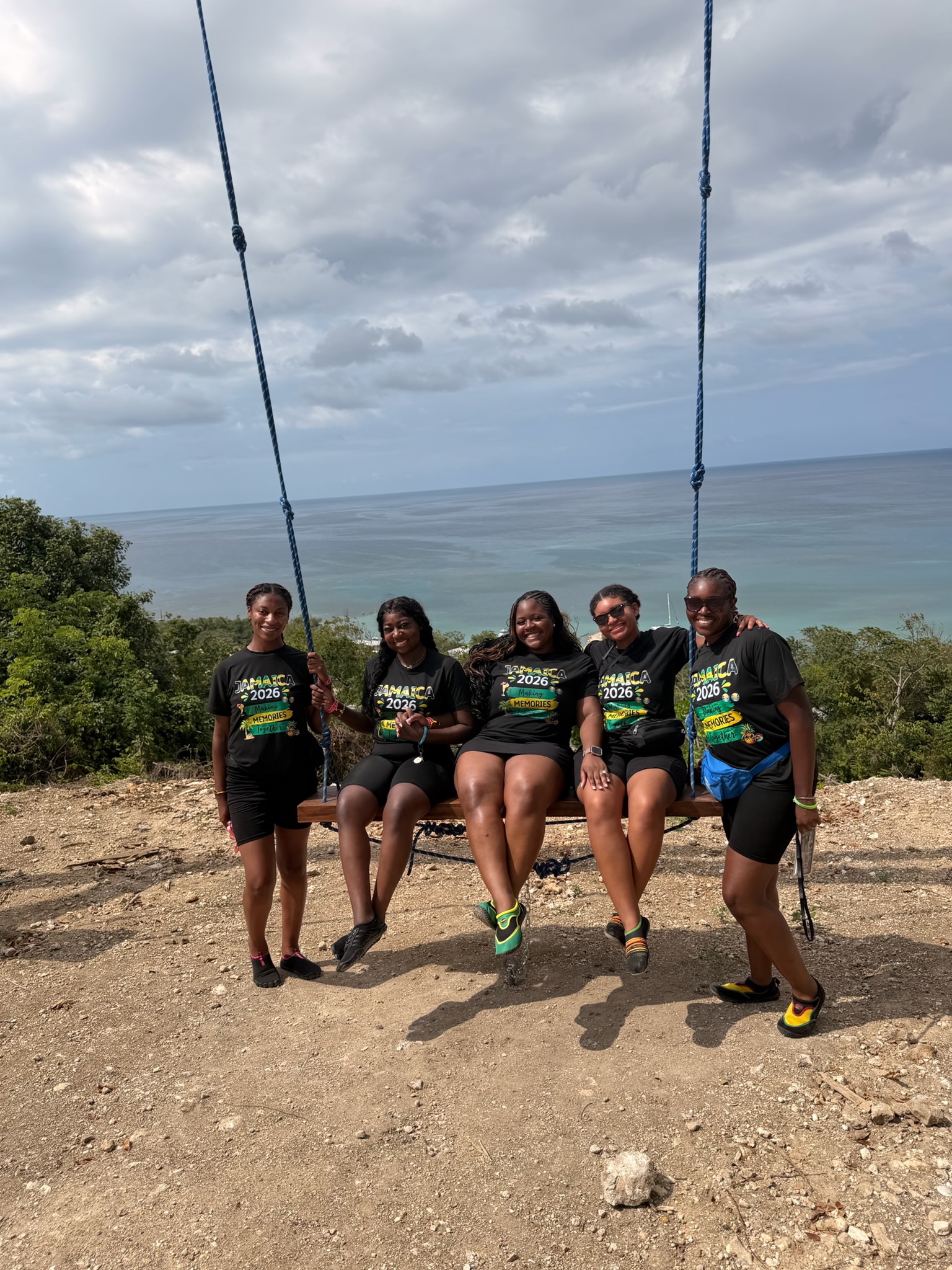 Kristy's group on a cliff swing in Jamaica with the ocean in the background, Jamaica 2026 trip